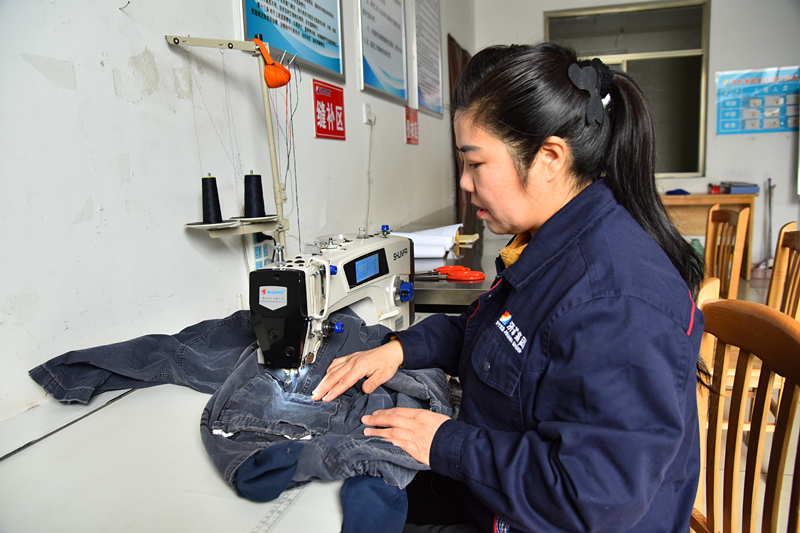 洗衣班班长华明娇在缝补工装